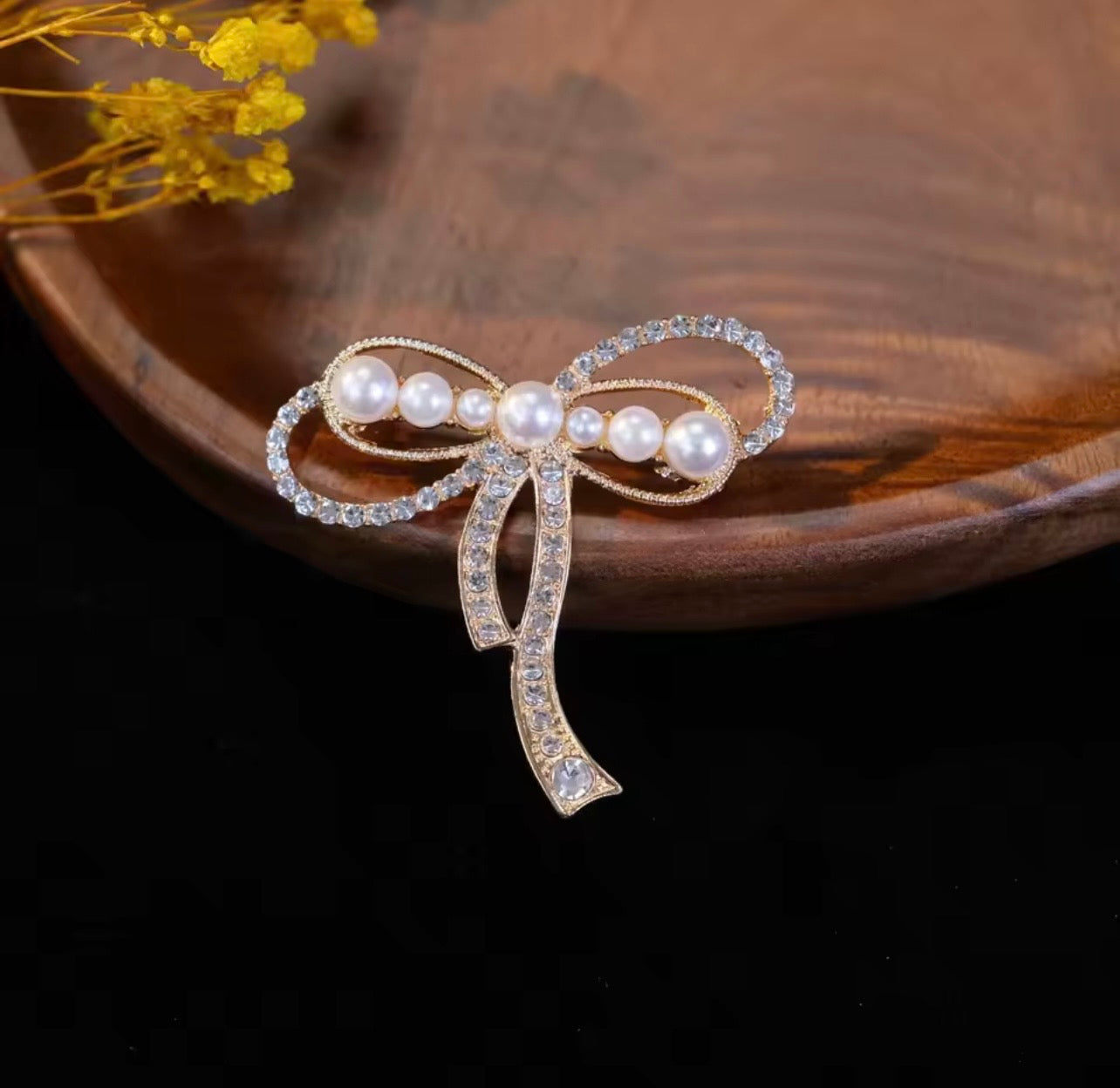 Elegante spilla a fiocco con perla e cristalli: un accessorio senza tempo per ogni occasione.